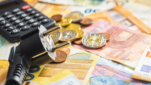 Un enchufe con una calculadora y euros