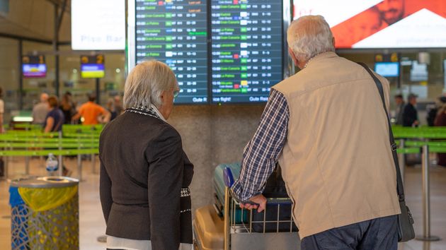 Dos jubilados esperan con maletas