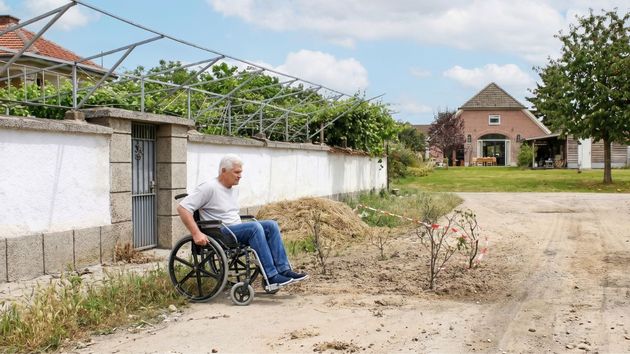 Un hombre en silla de ruedas pasando por un camino 