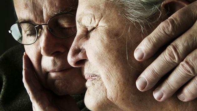 Dos jubilados tristes abrazándose
