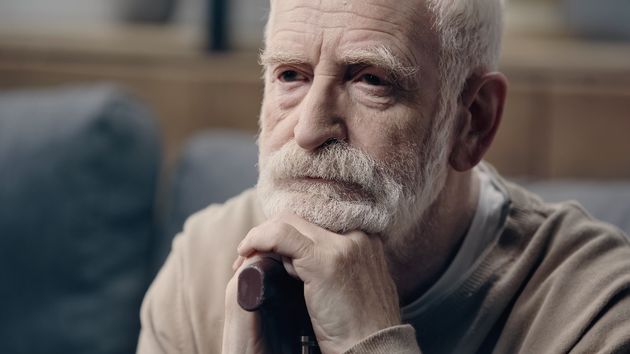 Un anciano apoyado en un bastón