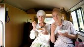dos jubilados comiendo dentro de una caravana