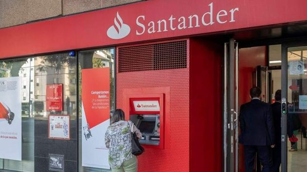 Una mujer sacando dinero en un cajero del Banco Santander