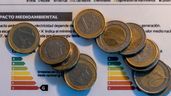 Monedas de euro sobre una factura de luz
