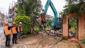 Operarios derribando la cancela de entrada a una propiedad