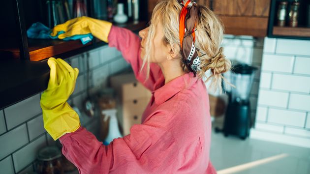 Una mujer limpiando mientras cocina