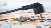 Un enchufe sobre billetes de euro
