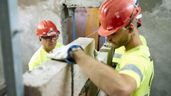 Dos albañiles trabajan levantando un tabique