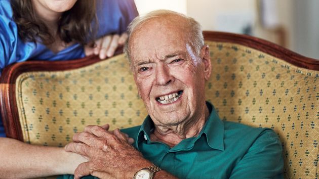 Un anciano coge la mano a su cuidadora