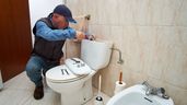 un fontanero arreglando un inodoro