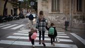 Una madre cruzando la calle con sus dos hijos