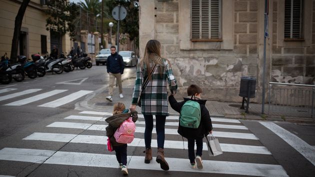 Una madre cruzando la calle con sus dos hijos