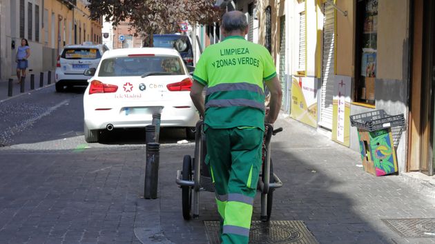 Un barrendero empuja su carro de la limpieza