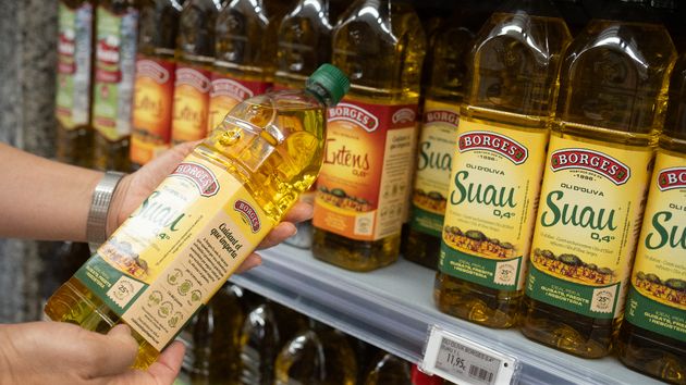 Una persona sostiene una botella de aceite