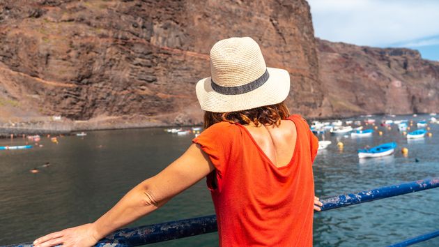 Una mujer de espaldas contemplando un puerto