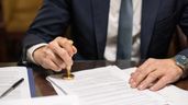 Un hombre firmando y sellando documentos 