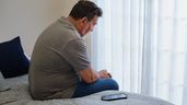 Un hombre triste con el móvil al lado