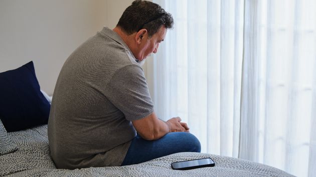 Un hombre triste con el móvil al lado