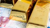 Varios lingotes de oro con billetes