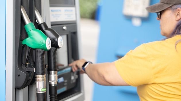 Una mujer repostando en una gasolinera