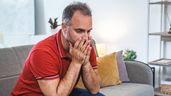 Hombre sentado en el sofá de su casa