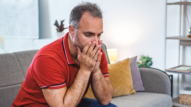 Hombre sentado en el sofá de su casa