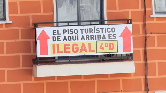 Cartel de un piso turístico ilegal en una comunidad de vecinos 