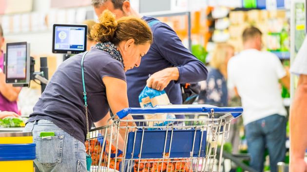 Varias personas hacen cola en un supermercado