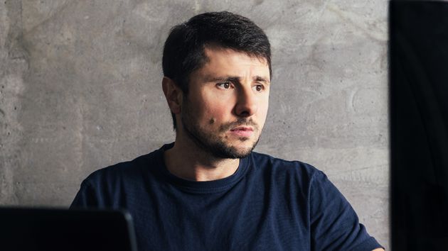 Un hombre aleatorio con mirada triste sentado en su escritorio