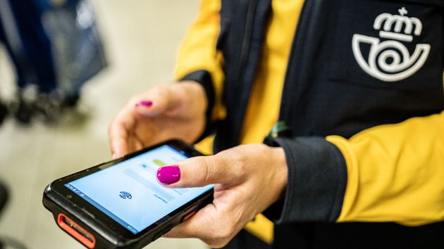Una trabajadora de correos con una pda