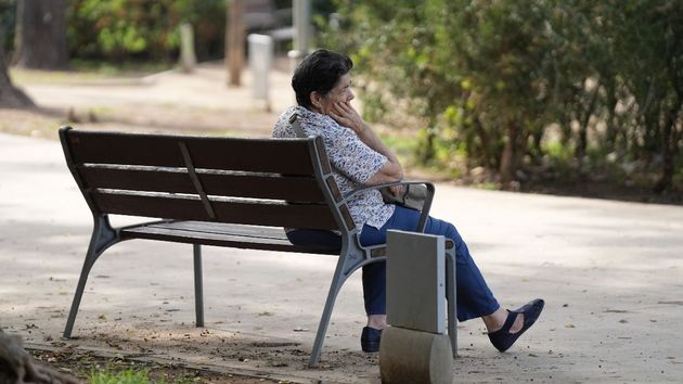Una jubilada sentada en un banco