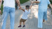Un niño saltando de la mano de sus padres