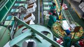 Varias personas trabajando en una fábrica manipulando frutas