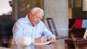 Imagen representativa de un anciano firmando un documento