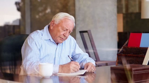 Imagen representativa de un anciano firmando un documento