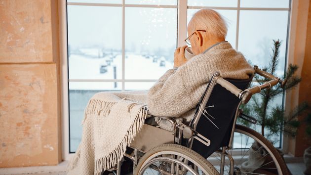 Un anciano mirando por la ventana