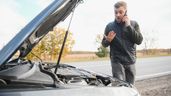 Un hombre mirando su coche averiado