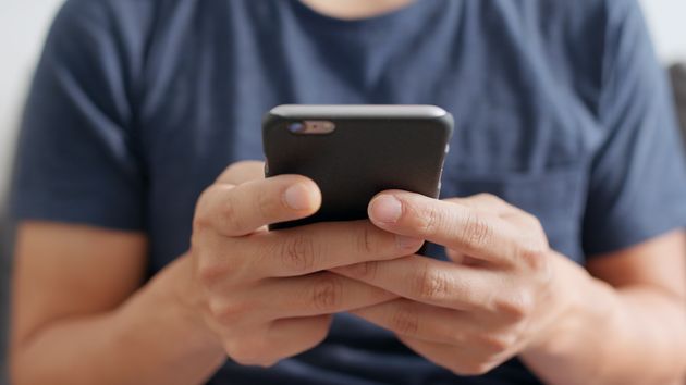 Un hombre escribiendo un mensaje con el móvil