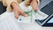Las manos de una mujer sosteniendo billetes de 100 euros 
