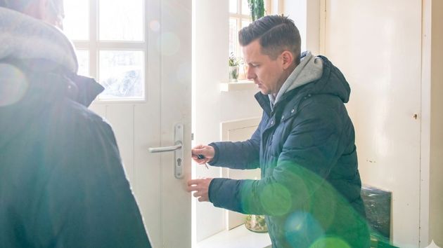 Imagen ilustrativa de un hombre abriendo la puerta de una vivienda 