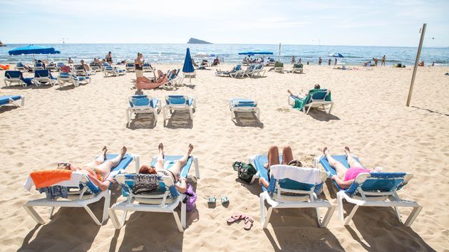 Un grupo aleatorio de personas tomando el sol en la playa