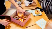 Varias personas compartiendo una caja de donuts