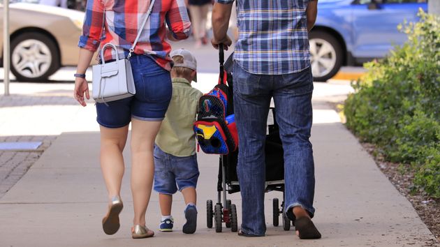 Una familia pasea con su hijo por la calle