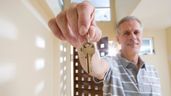 Imagen representativa de un hombre con las llaves de una vivienda en la mano