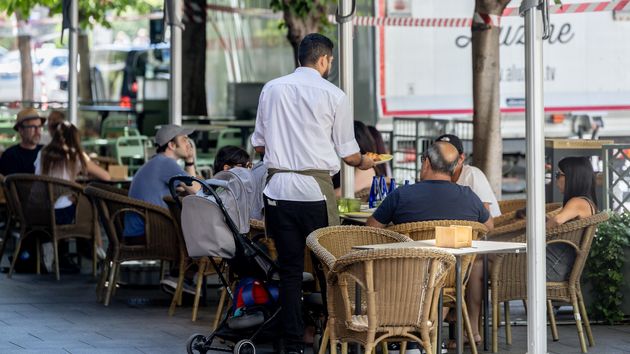 Un camarero atendiendo la terraza de un bar