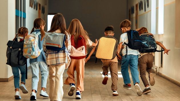 Niños corriendo en un pasillo por la vuelta al cole