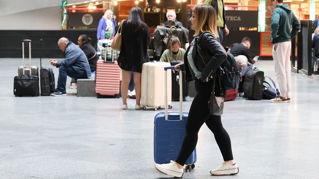 Numerosas personas con maletas esperan para viajar en la estación