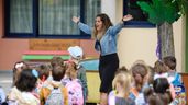 Una maestra saludando a los niños