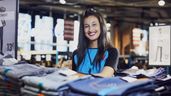 Una trabajadora de Primark delante de un mostrador de ropa