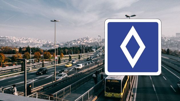 una señal de diamante y una carretera de ciudad